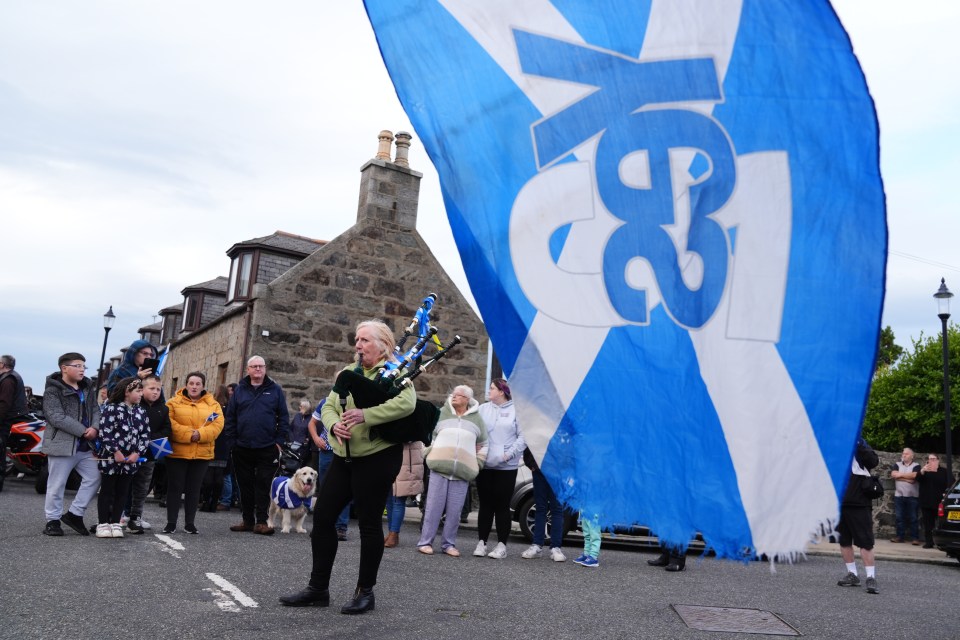 A piper plays outside after Mr Salmond's coffin was taken into Fraserburgh Funeral Services