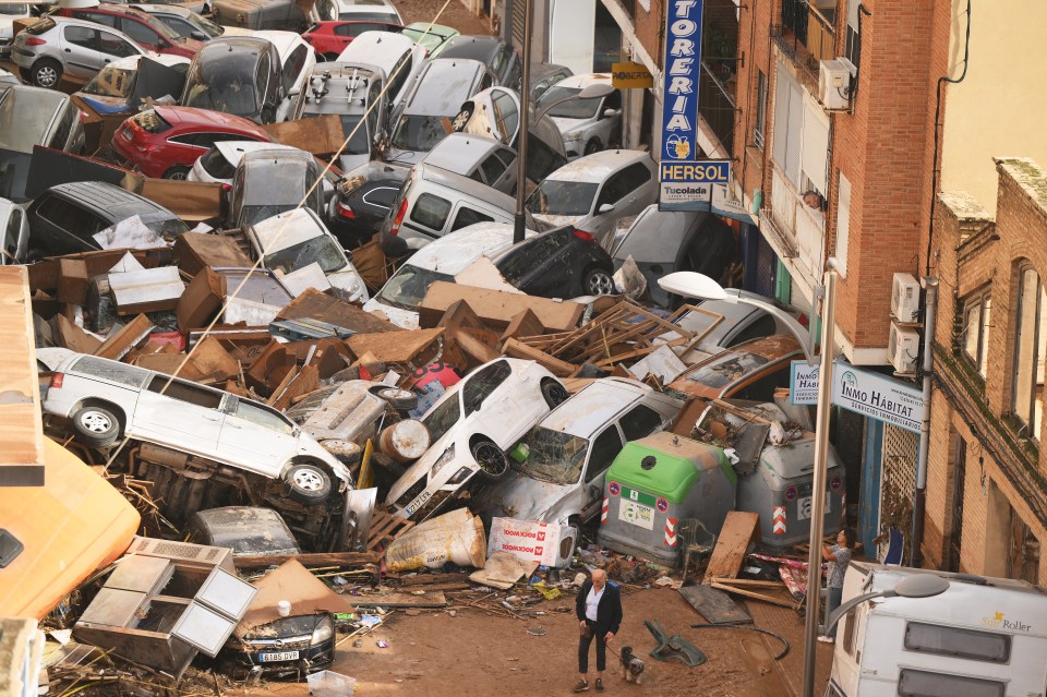 Cars are piled in the street with other debris after flash floods hit the Valencia region