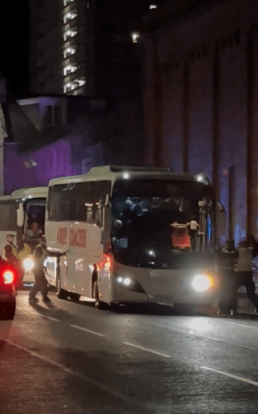 Officers can be seen at both sides of the coach outside Pittodrie Stadium