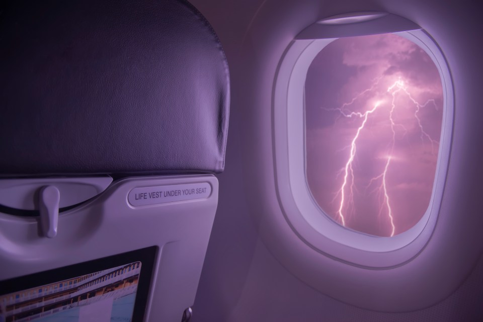 Lightning storm viewed from inside an aeroplane window