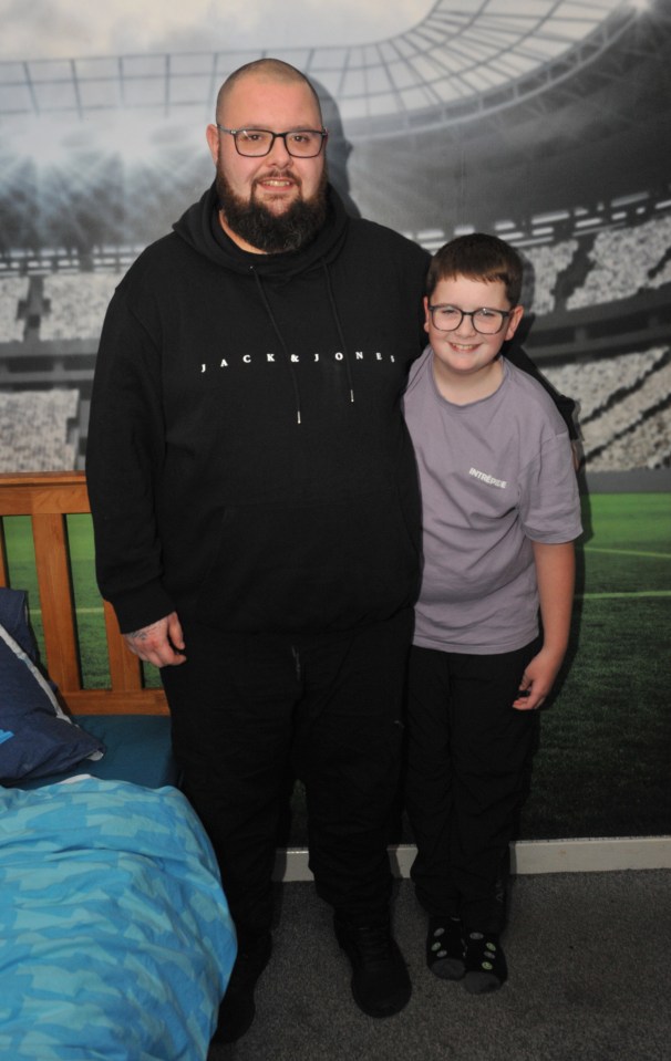 a man wearing a black jack & jones hoodie stands next to a boy