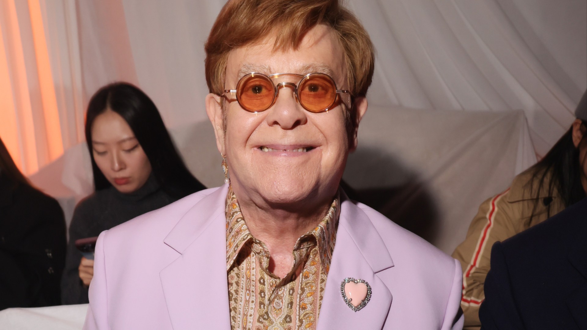 Huge British supermodel transforms into Elton John for new Step Into Christmas music video