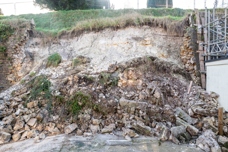 The collapsed wall has made a mess of her driveway