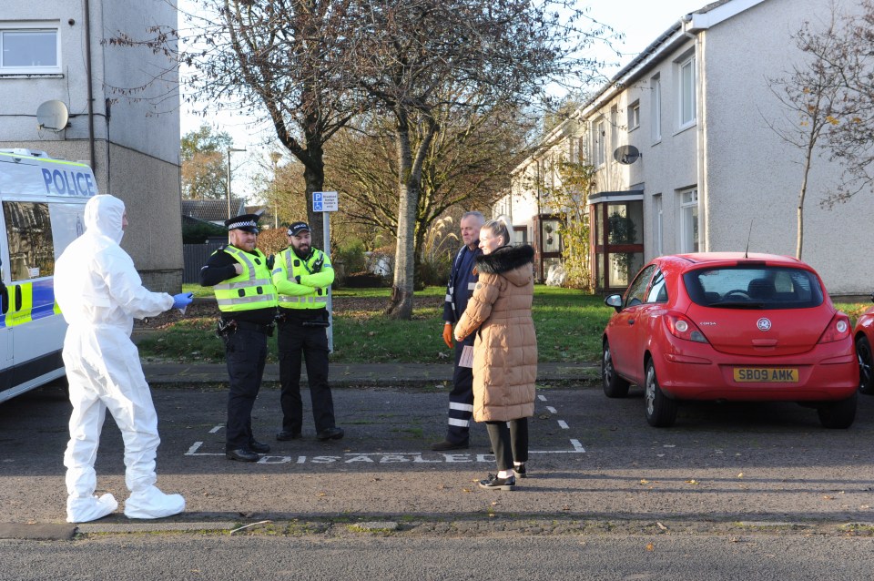 Forensic officers in white coats scoured the surrounding area for clues