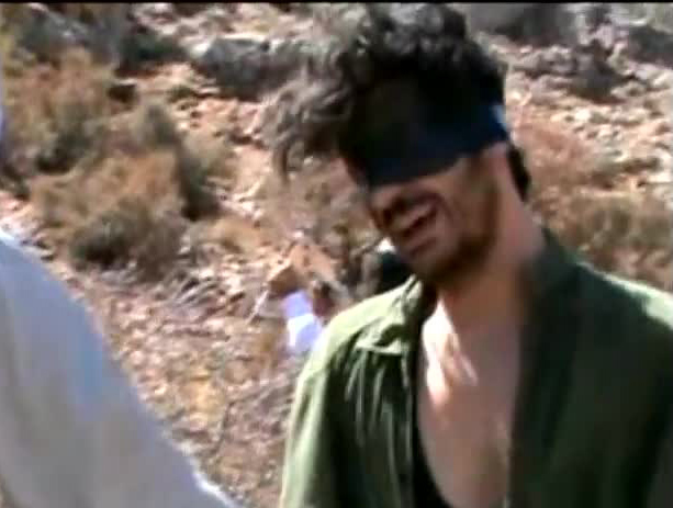 An image shows American freelance journalist Austin Tice blindfolded with men believed to be his captors at an undisclosed location in Syria