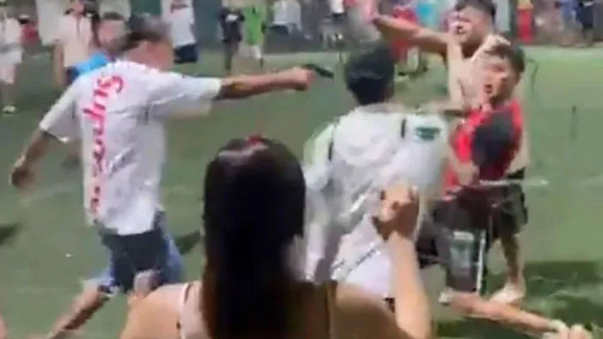 Shocking moment gunman shoots pistol during mass brawl between football players as others flee for safety