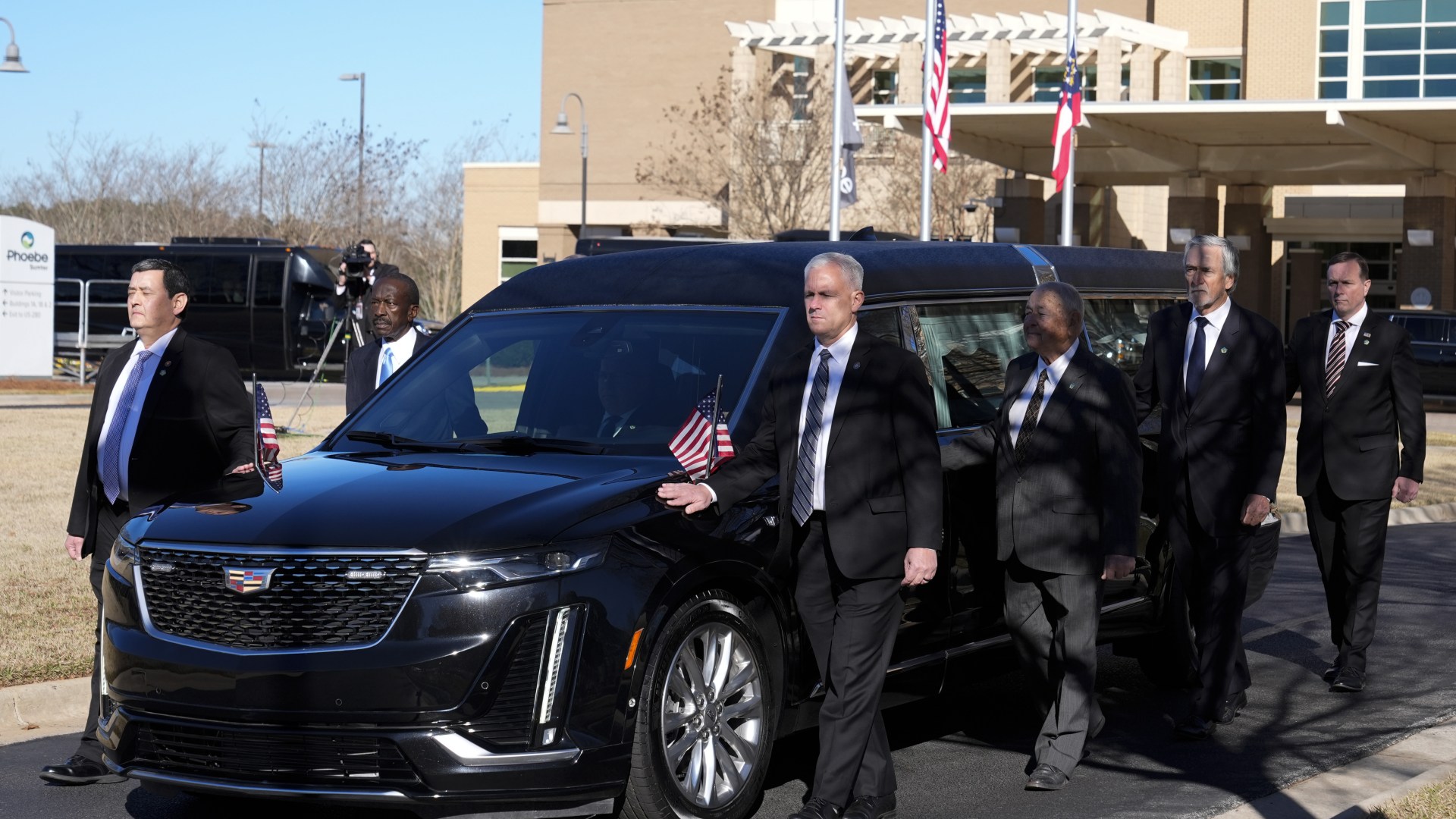 Stony-faced US Secret Service guards carry ex President Jimmy Carter's flag-draped coffin as 6-day state funeral begins